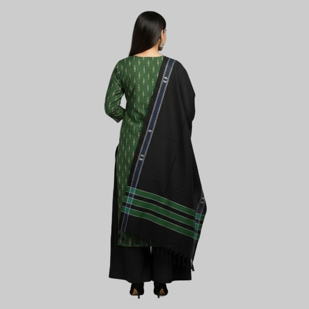 Woman wearing a green and black traditional outfit with a matching scarf on a gray background