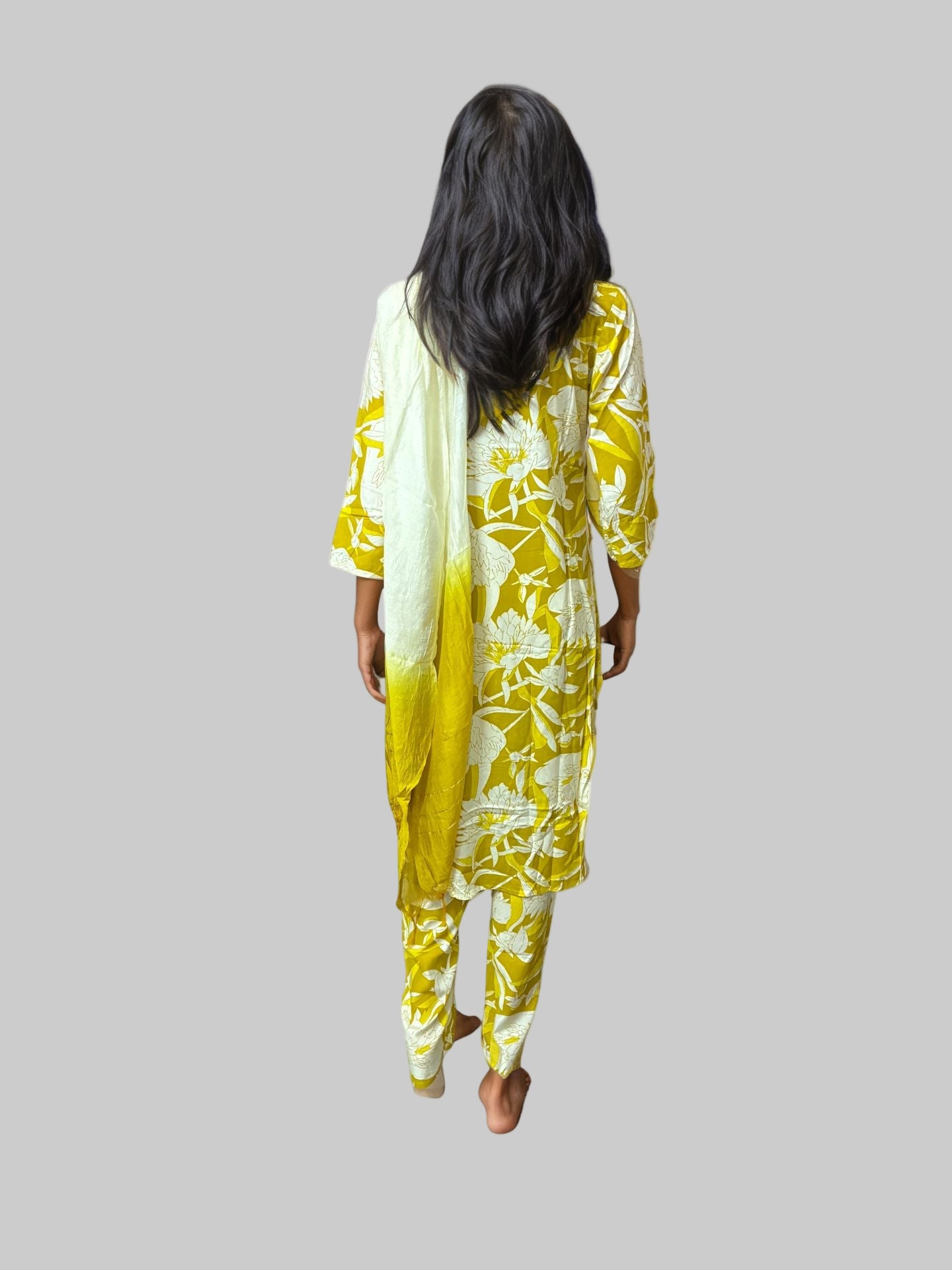 Woman wearing a yellow and white floral outfit on a white background