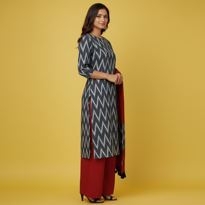 Woman wearing a gray and red patterned kurta with a red scarf on a yellow background