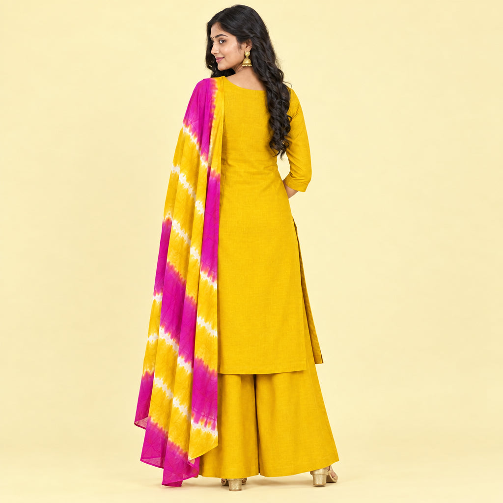 A woman models a mustard yellow ethnic salwar kameez suit with a magenta and yellow tie-dye dupatta against a plain white background.