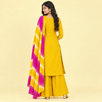 A woman models a mustard yellow ethnic salwar kameez suit with a magenta and yellow tie-dye dupatta against a plain white background.