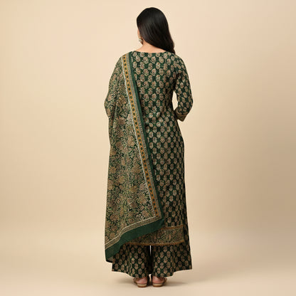 Woman wearing a green and gold traditional outfit on a beige background