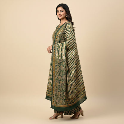 Woman wearing a green and gold traditional outfit on a beige background