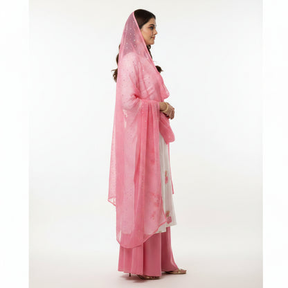 Woman wearing a pink and white traditional outfit with a matching dupatta on a white background