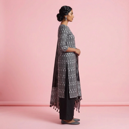A woman modeling a traditional Indian outfit consisting of a black and gray patterned kurta, black pants, and a matching dupatta, set against a plain light gray studio background.