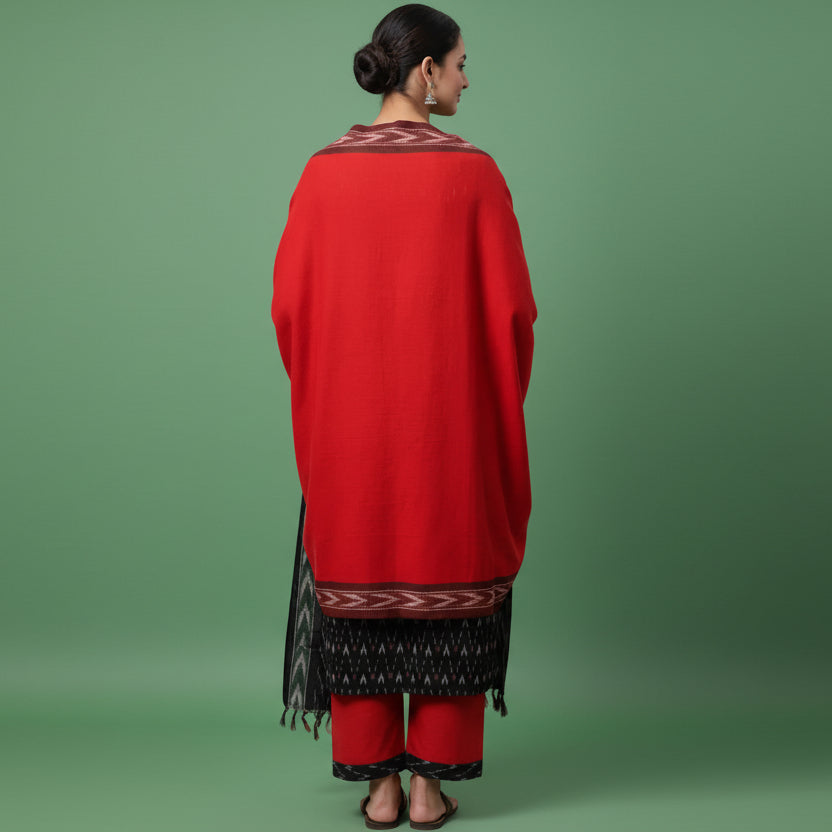 Woman wearing a red and black traditional outfit on a gray background
