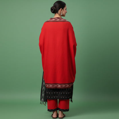 Woman wearing a red and black traditional outfit on a gray background
