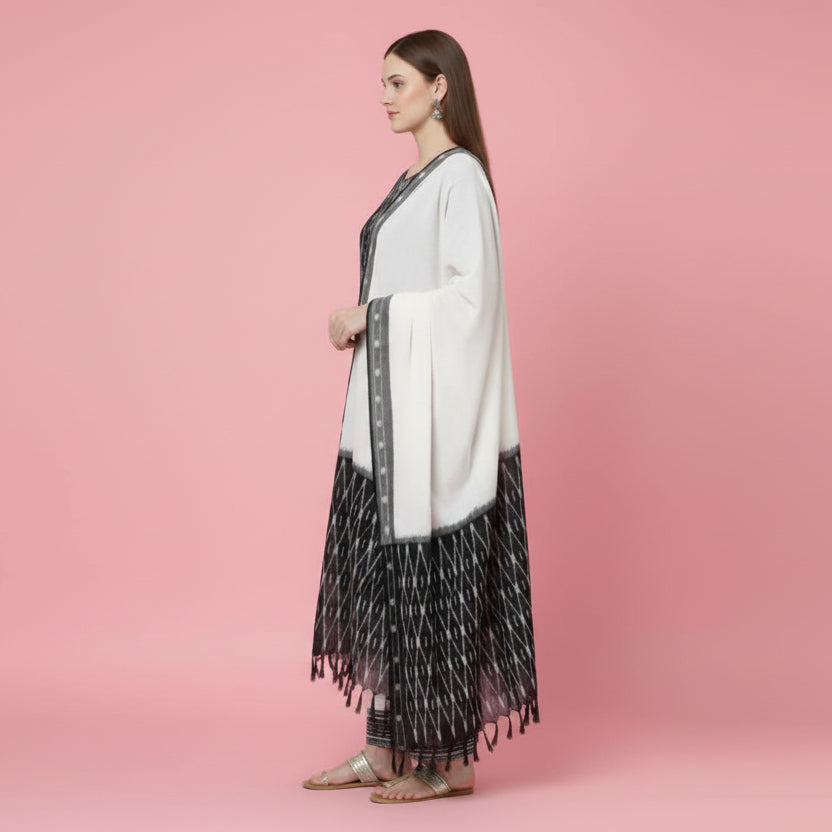 Woman wearing a black and white patterned outfit with a scarf on a white background