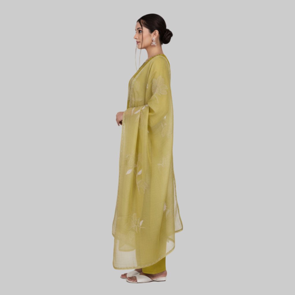 Woman wearing a green traditional outfit with a matching dupatta on a white background