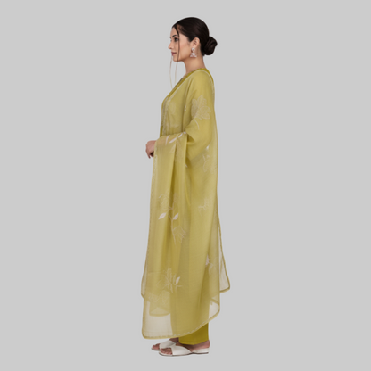 Woman wearing a green traditional outfit with a matching dupatta on a white background