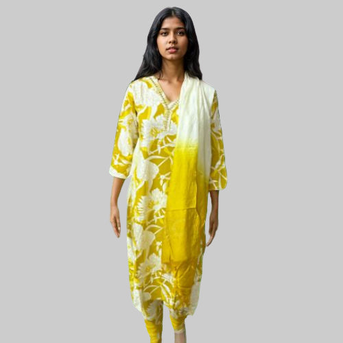 Woman wearing a yellow and white dress with a forest background