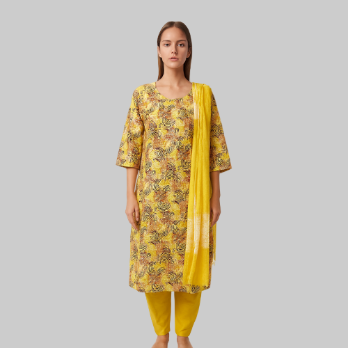 Woman wearing a yellow patterned kurta with matching pants and dupatta on a white background