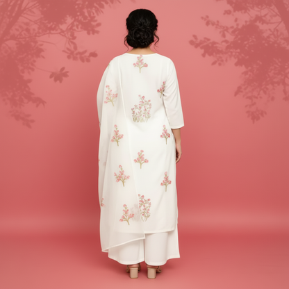 Woman wearing a white outfit with floral patterns on a pink background